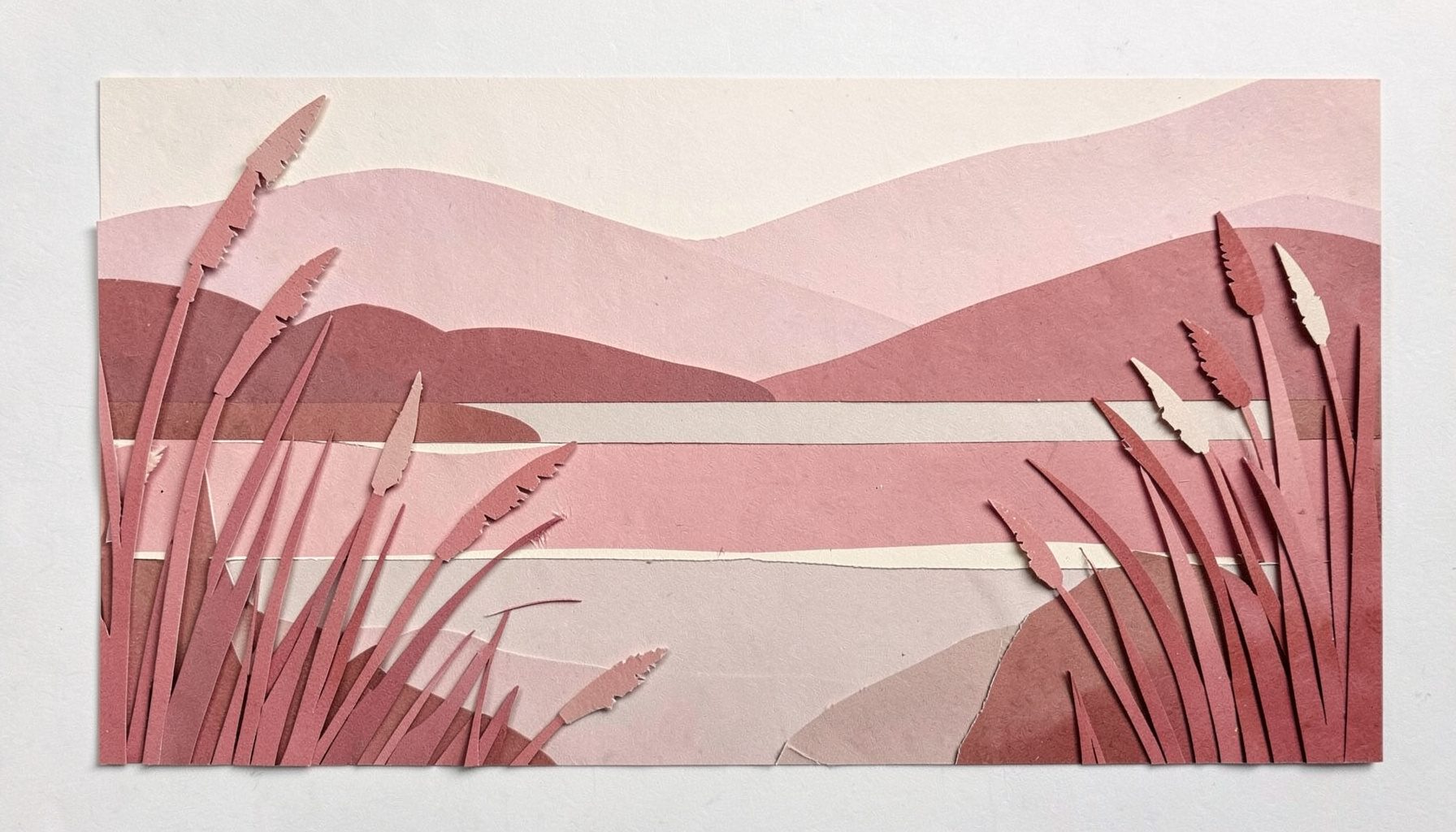 A layered paper cut-out collage of riverside reeds and soft hills at dusk, muted blush and dusty rose tones with cream highlights