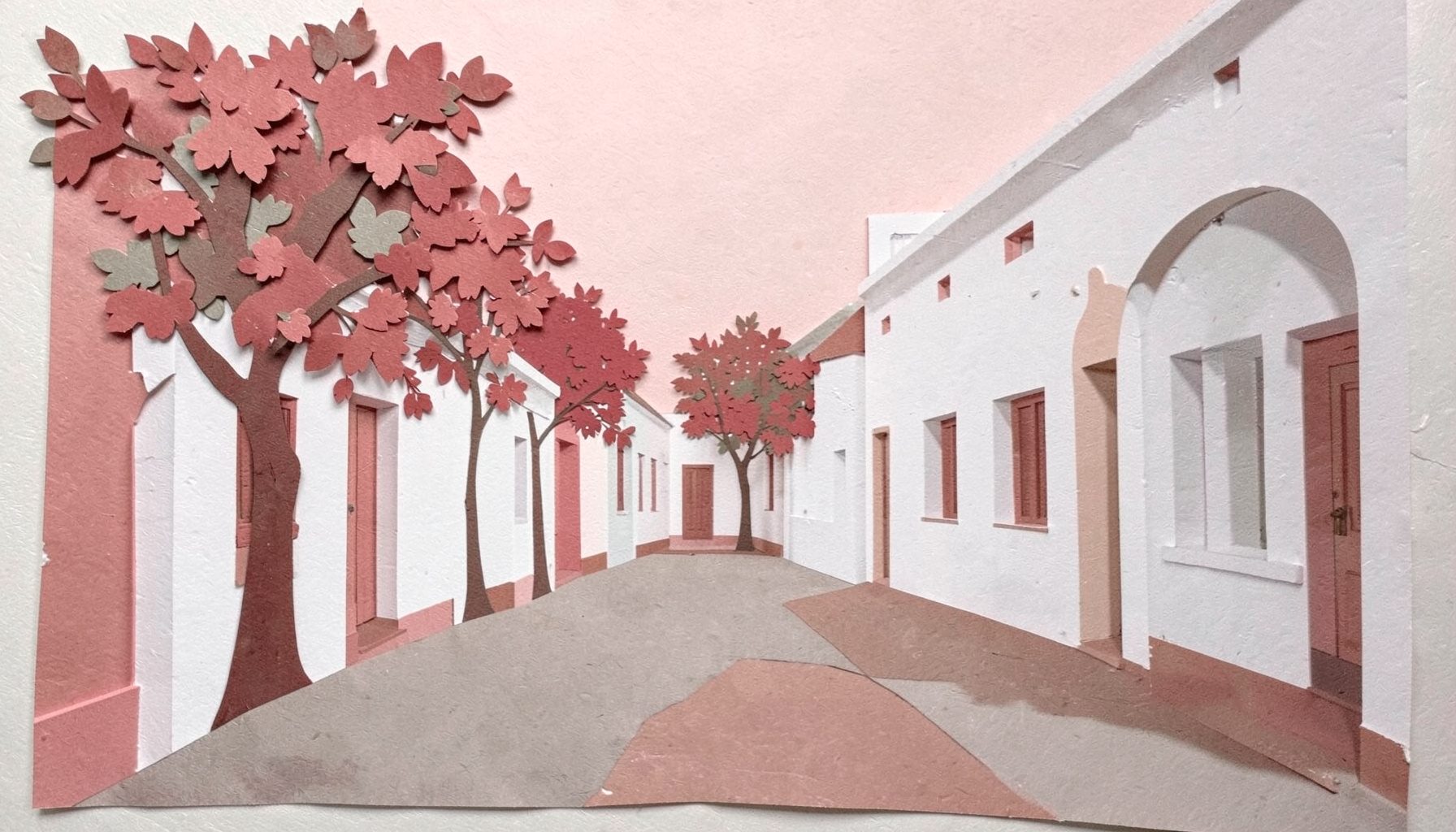 A layered paper cut-out collage of a quiet colonial street with low whitewashed buildings and flowering trees, gentle pink and cream tones